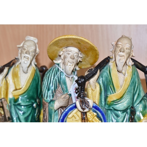 816 - A GROUP OF THREE CHINESE EXPORT MUD MEN FIGURES comprising two different figures carrying items with... 