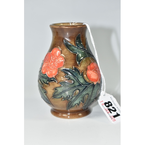 821 - A MOORCROFT POTTERY BALUSTER VASE, tube-lined with red flowers and forest green leaves on a brown gr... 
