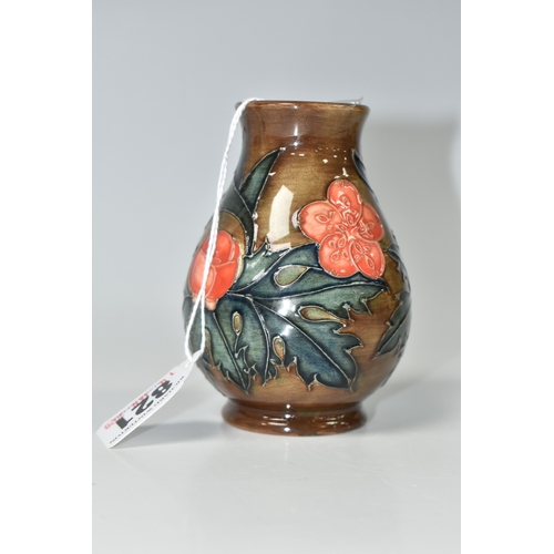 821 - A MOORCROFT POTTERY BALUSTER VASE, tube-lined with red flowers and forest green leaves on a brown gr... 