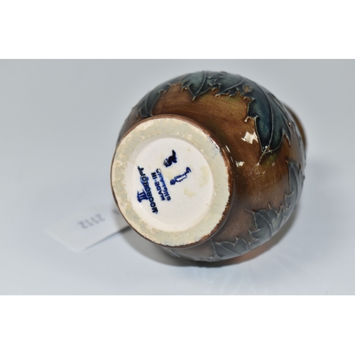 821 - A MOORCROFT POTTERY BALUSTER VASE, tube-lined with red flowers and forest green leaves on a brown gr... 