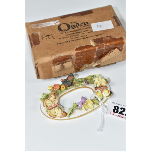 822 - A LATE NINETEENTH STEVENSON AND HANCOCK MENU CARD HOLDER, modelled with flowers and butterflies, pai... 