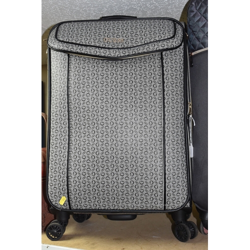 A GUESS CASSIAN MEDIUM SOFT SHELL SUITCASE, featured in grey with ...