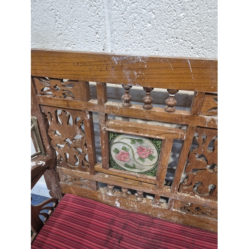 306 - AN ANGLO INDIAN TEAK BENCH, with a railway-style swinging back rest, inlaid with various tiles, rais... 