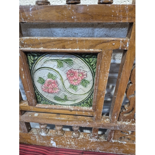 306 - AN ANGLO INDIAN TEAK BENCH, with a railway-style swinging back rest, inlaid with various tiles, rais... 