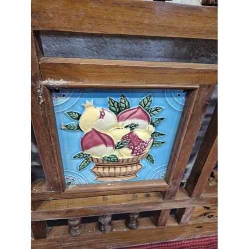 306 - AN ANGLO INDIAN TEAK BENCH, with a railway-style swinging back rest, inlaid with various tiles, rais... 