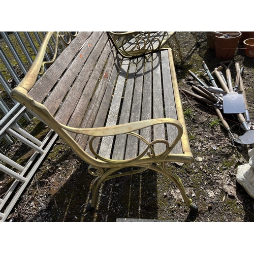 10 - A CAST IRON GARDEN BENCH AND TWO MATCHING CHAIRS with a bench 124cm wide, all with scrolled detail t... 