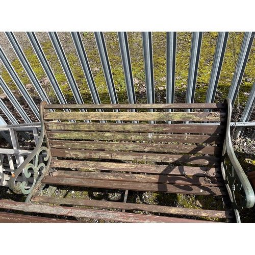 18 - A PAIR OF CAST IRON GARDEN BENCHES with wooden slatted seats and backs, 129cm wide. Condition Report... 