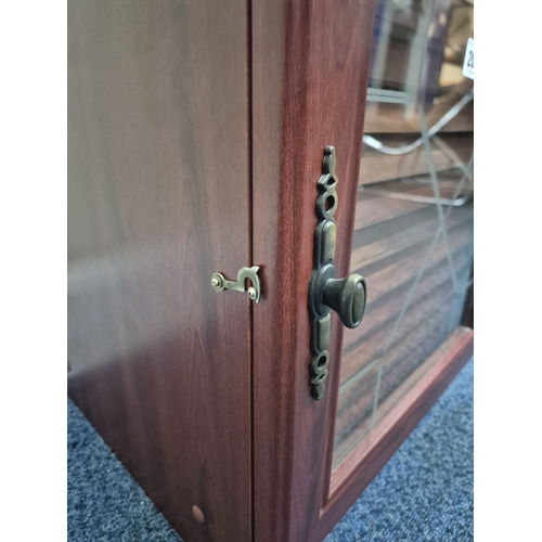 209 - A REPRODUCTION MAHOGANY EFFECT COLLECTORS CABINET, the single glass door enclosing fourteen shallow ... 