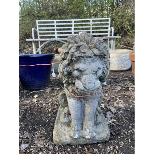 14 - A WEATHERED CONCRETE FIGURE DEPICTING A SEATED LION on a square pad base, 44cm high