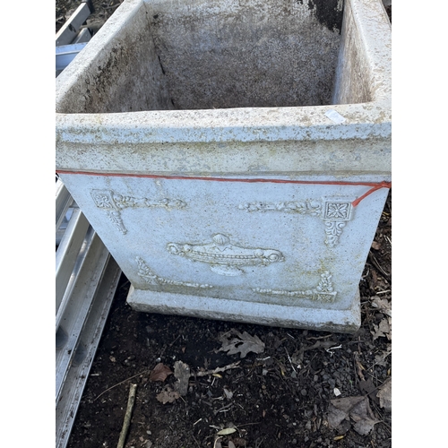 18 - A PAIR OF LARGE SQUARE CONCRETE PLANTERS, with ewers detail to each facet, both 48cm across
