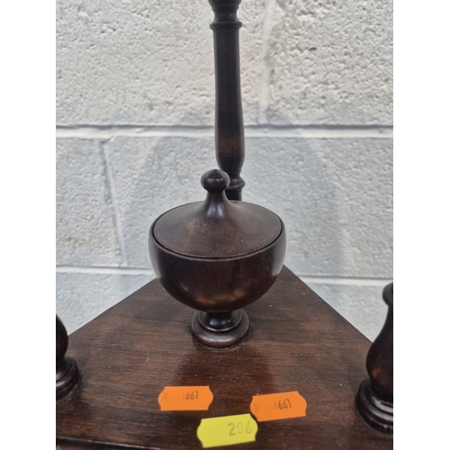 200 - A MAHOGANY WIG STAND, with a circular top, the triangle centre section with a lidded cup and two dra... 