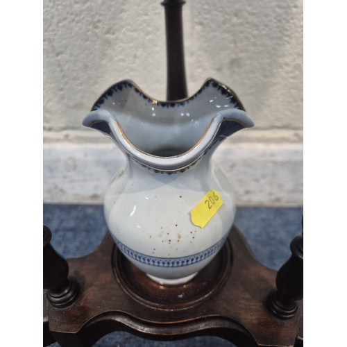 200 - A MAHOGANY WIG STAND, with a circular top, the triangle centre section with a lidded cup and two dra... 