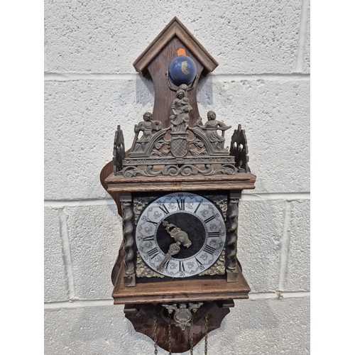 364 - TWO ZAANSE WALL CLOCKS, with brass figures holding a globe and raised gallery, one with two weights,... 