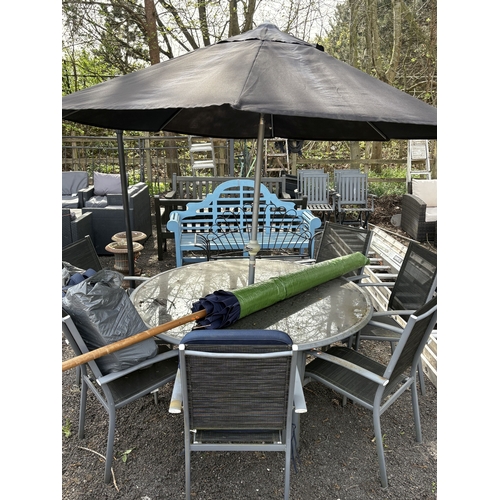 13 - A METAL AND GLASS CIRCULAR GARDEN TABLE, diameter 152cm, height 68cm, six stackable armchairs with l... 