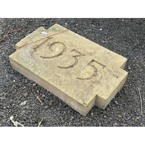 27 - A WEATHERED CONCRETE WALL STONE, carved with the year, 1935, 68cm x 44cm, condition report: appears ... 