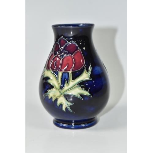 1013 - A MOORCROFT POTTERY 'ANEMONE' VASE, the small baluster vase tube lined with purple anemone flowers o... 