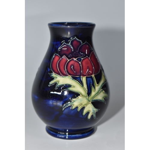815 - A MOORCROFT POTTERY 'ANEMONE' VASE, the small baluster vase tube lined with purple anemone flowers o... 
