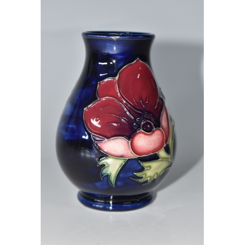 815 - A MOORCROFT POTTERY 'ANEMONE' VASE, the small baluster vase tube lined with purple anemone flowers o... 