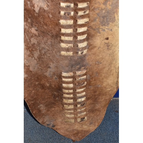 843 - AN AFRICAN ZULU STYLE SHIELD of traditional elongated oval form, constructed from animal hide with r... 