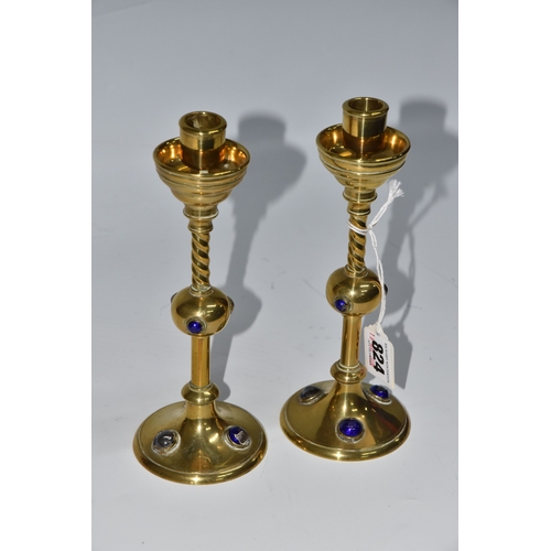 824 - A PAIR OF GEORGE BETJEMANN & SONS CANDLESTICKS, the brass arts and crafts style candlesticks with bl... 
