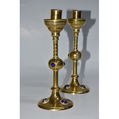 824 - A PAIR OF GEORGE BETJEMANN & SONS CANDLESTICKS, the brass arts and crafts style candlesticks with bl... 
