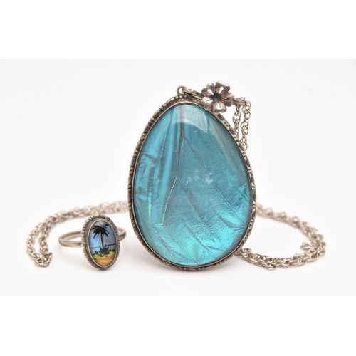 472 - A LARGE WHITE METAL BUTTERFLY WING PENDANT WITH RING, a large tear drop form pendant, fitted with a ... 