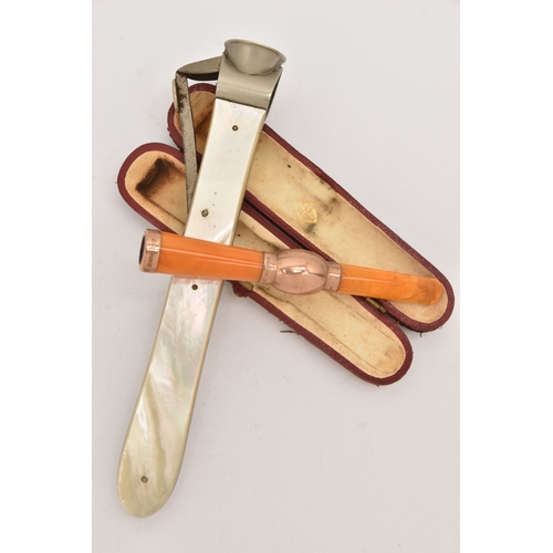 514 - A CASED AMBER AND GOLD CHEROOT AND A CIGAR CUTTER, the polished amber cheroot with rose gold mounts,... 