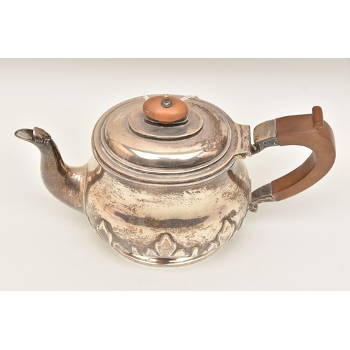 524 - AN EARLY 20TH CENTURY SILVER TEAPOT, foliate pattern, fitted with a light wooden handle and finial, ... 