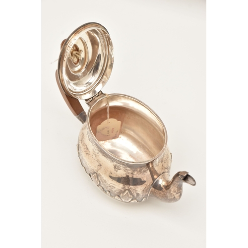 524 - AN EARLY 20TH CENTURY SILVER TEAPOT, foliate pattern, fitted with a light wooden handle and finial, ... 