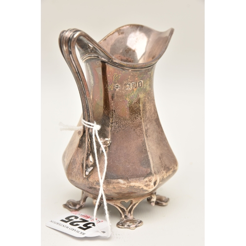 525 - AN EARLY 20TH CENTURY SILVER MILK JUG, faceted form with scroll handle, raised on four feet, hallmar... 