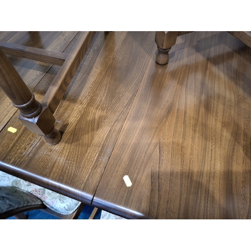 201 - LUCIAN ERCOLANI, AN ERCOL ELM AND BEECH EXTENDING DINING TABLE, with three additional leaves, raised... 