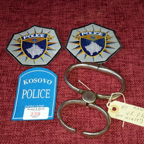 239 - Figure 8 light steel grip hand cuffs by W.R.Pape & 3 police patches