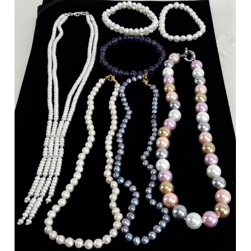 47 - A collection of freshwater pearls, some with pastel shading and one purple glass bracelet