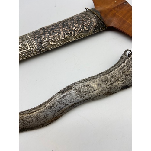 5A - A 19th century Kris or Keris dagger with silver ornate sheath. Handle is made of wood and silver mou... 