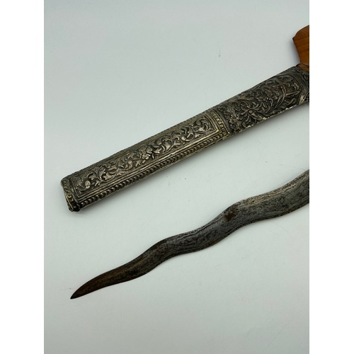 5A - A 19th century Kris or Keris dagger with silver ornate sheath. Handle is made of wood and silver mou... 