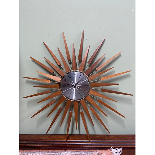 65A - A Retro teak and metal Sunburst wall clock by Seth Thomas, Quartzmatic. [66cm diameter]