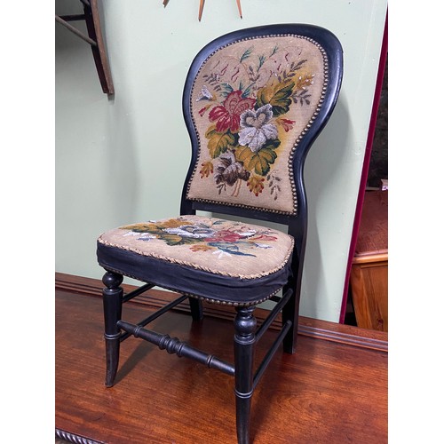 69A - A Victorian balloon back chair designed with a needlework tapestry back rest and seat area.