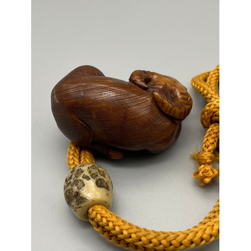 160J - A Meiji period hand carved Japanese netsuke of an Ox laying down, Design with black bead eyes, signe... 