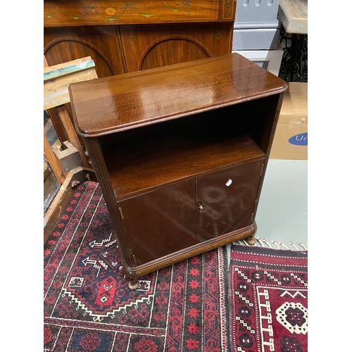 122A - A 20th century mahogany console unit. Designed with a shelving area, two doors which revealing a sto... 