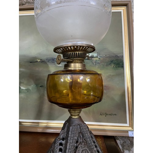 431B - A 19th century cast metal, amber glass and frost glass shade paraffin lamp.