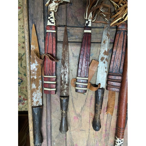 443A - A Tribal leather covered bow with arrows and satchel, Together with three tribal leather covered dag... 