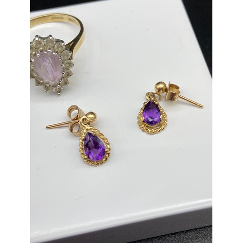 8J - A 9ct gold ladies ring set with a pale purple tear drop stone surrounded by clear stones, Together w... 