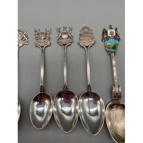 25 - A Lot of seven Birmingham Silver souvenir tea spoons. Some designed with enamel tops.