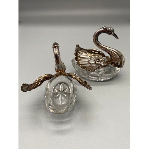 26 - A Pair of Import London silver swan salt dishes. Designed with articulated wings and crystal cut bod... 