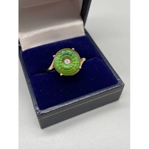 37 - An exquisite designed ladies 9ct/10K gold ring. Designed with a large green round cut stone with a s... 