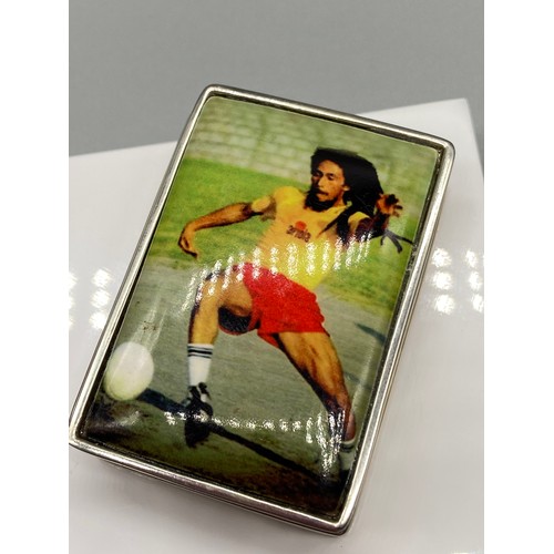 53J - A Silver 925 pill box with an enamel lid depicting Bob Marley playing football. [Measures 1.5x5x3.5c... 