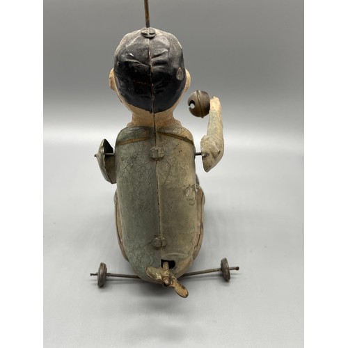 120 - Antique tinplate clockwork man seated with clapping bells. In a working condition.