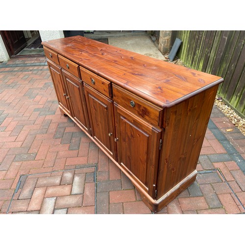 582 - A Pine Ducal four drawer, four door sideboard.