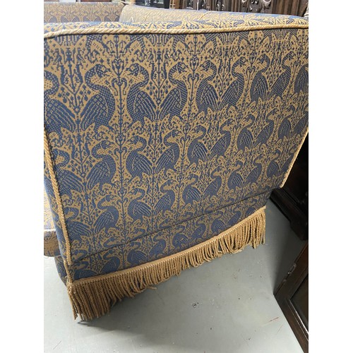 112A - A large Antique knole sofa. Upholstered with a gilt and blue bird design material. A piece from Libe... 