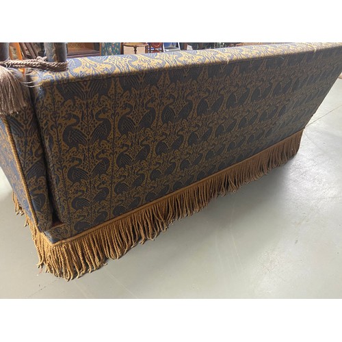 112A - A large Antique knole sofa. Upholstered with a gilt and blue bird design material. A piece from Libe... 